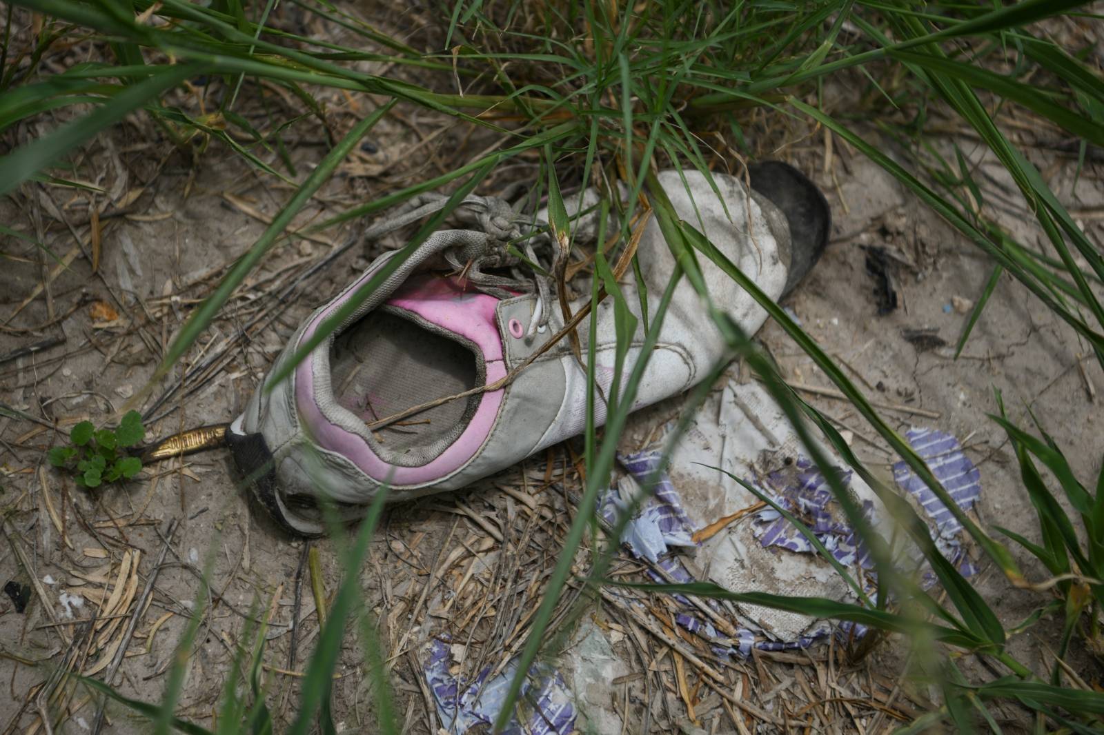 An abandoned shoe is seen by a migrant crossing on the Rio Grande at the U.S.-Mexico border in Mission
