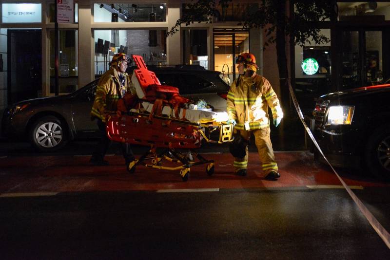 New York City firefighters use wheeled stretcher to carry supplies near site of explosion in New York