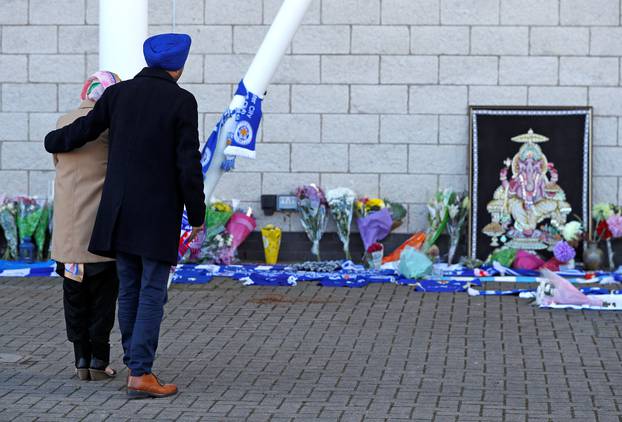 Leicester City football fans pay their respects outside the football stadium, after the helicopter of the club owner Thai businessman Vichai Srivaddhanaprabha crashed when leaving the ground on Saturday evening after the match, in Leicester