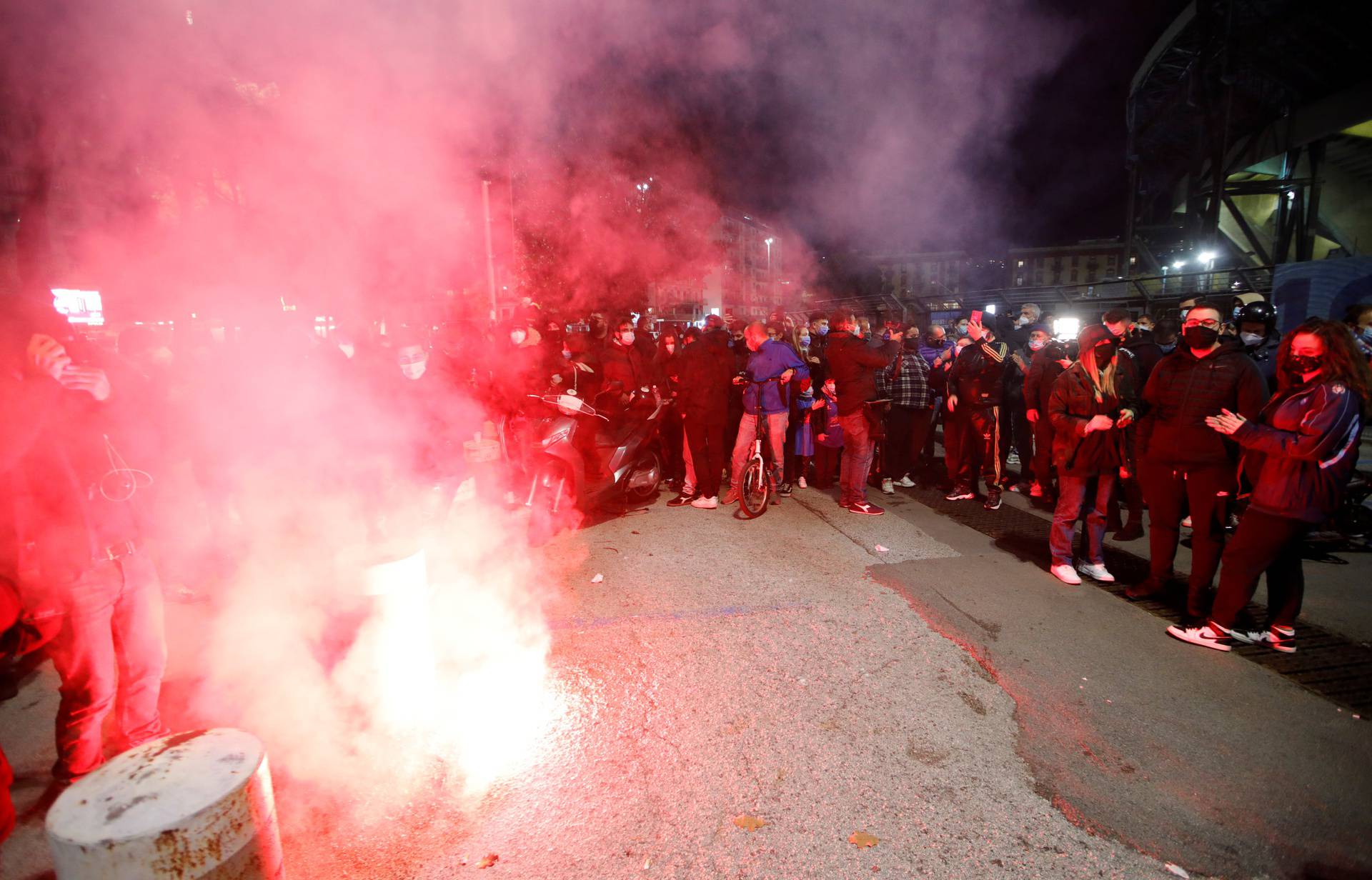 People gather to mourn the death of Argentine soccer legend Diego Maradona outside San Paolo stadium in Naples