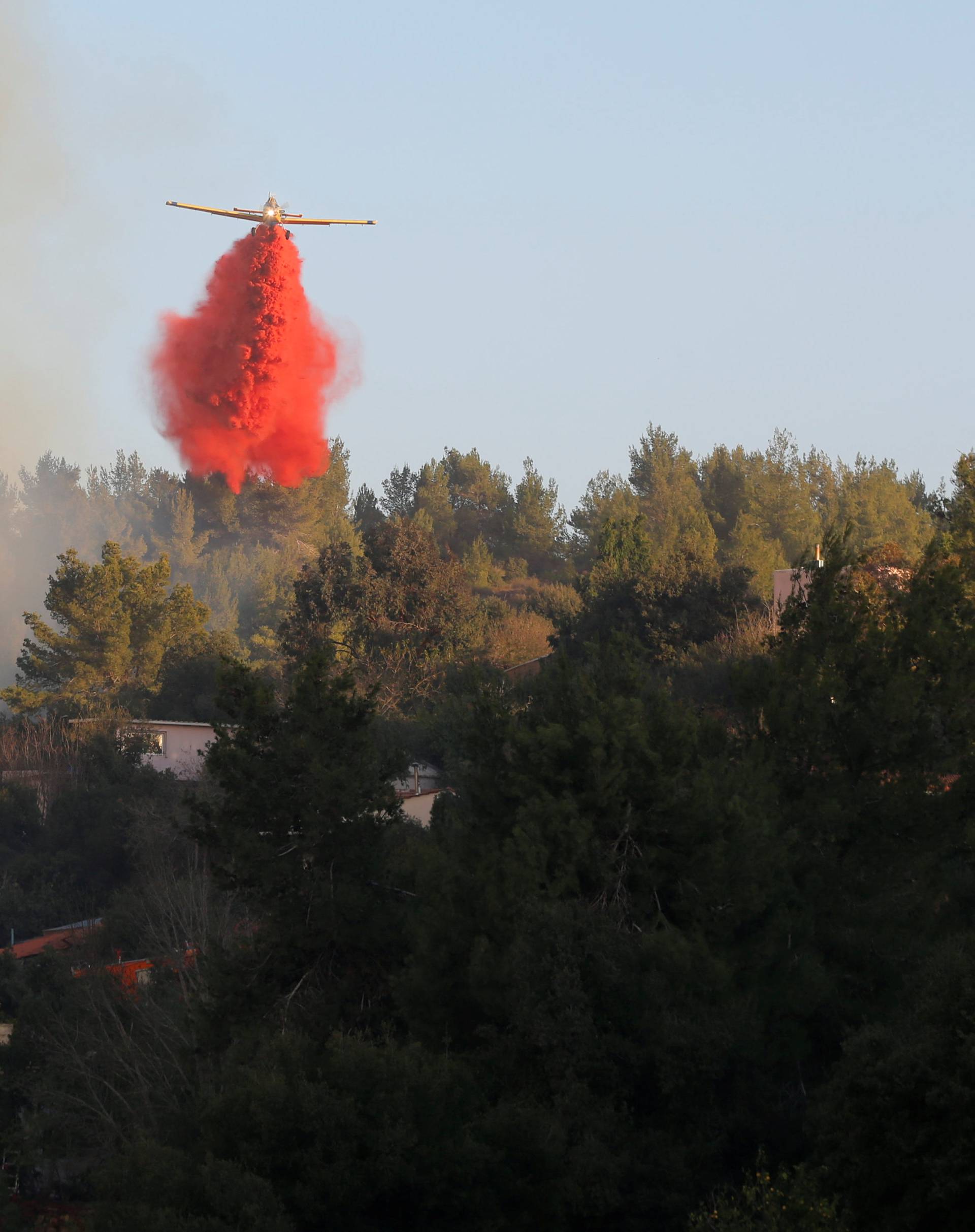 A firefighting plane drops fire retardant during a wildfire, around the communal settlement of Nataf, close to Jerusalem 