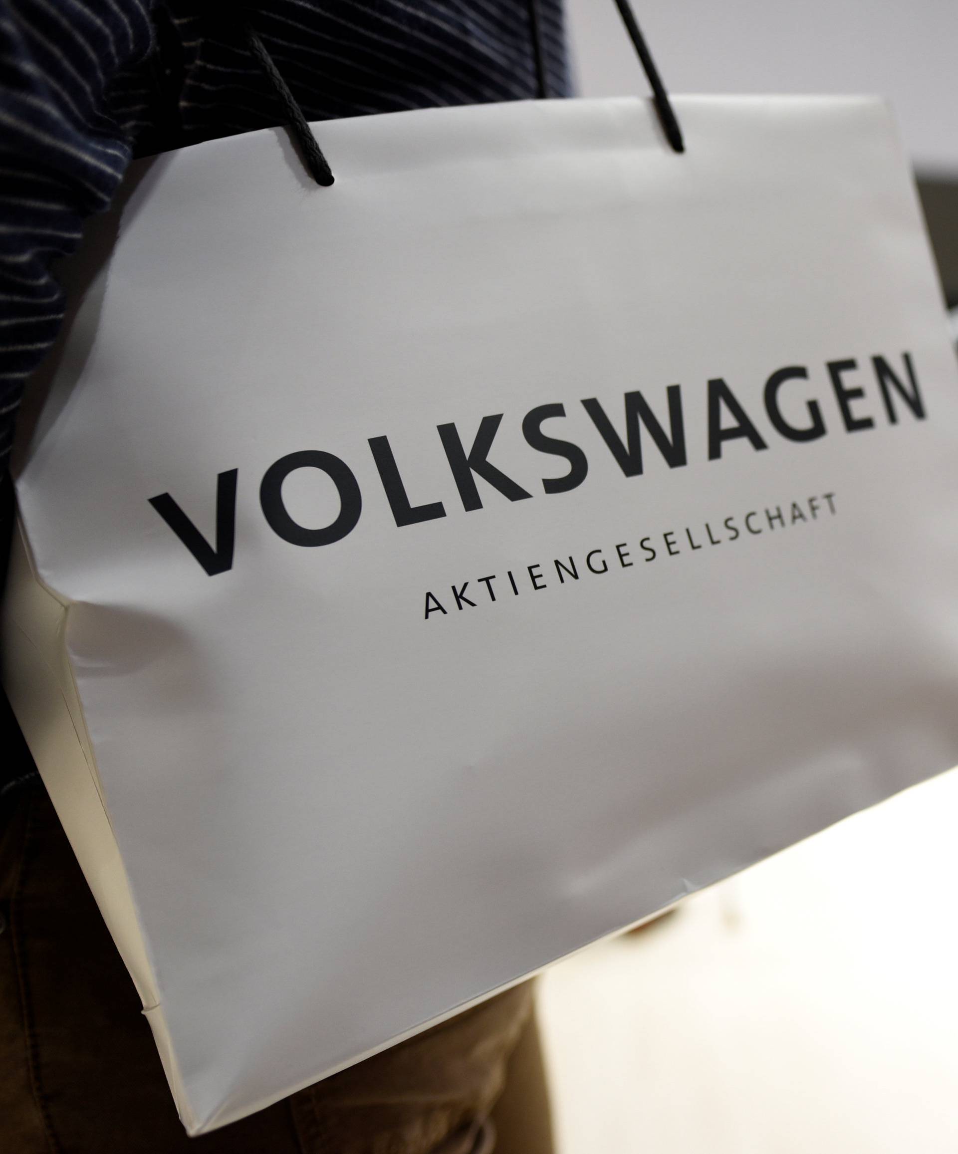 A Volkswagen shareholder carries a bag at the annual shareholder meeting in Hanover