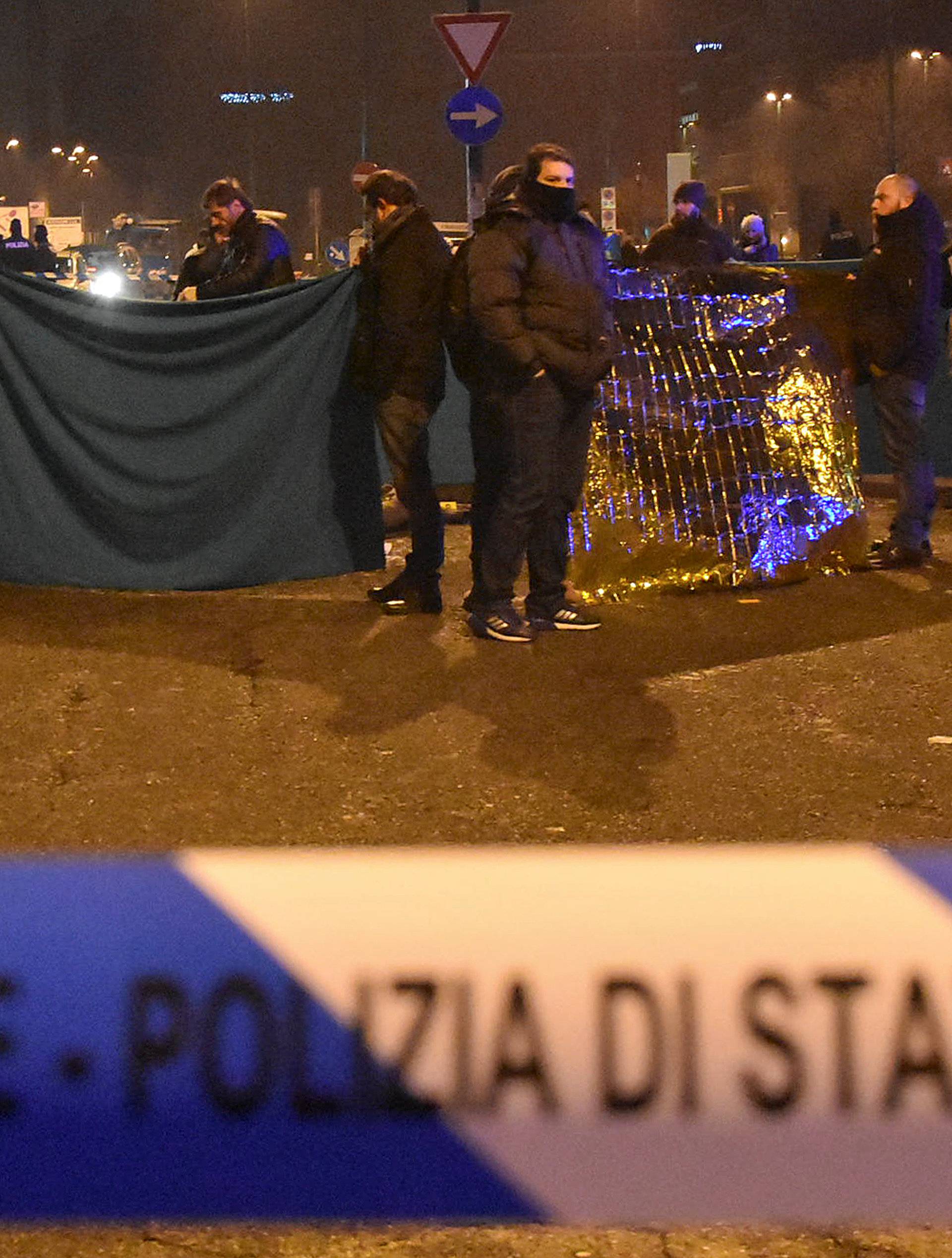 Italian Police officers work next to the body of Anis Amri, the suspect in the Berlin Christmas market truck attack, in a suburb of the northern Italian city of Milan