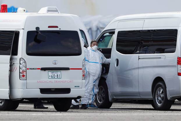 Ambulance workers in protective gear prepare to transfer coronavirus patients from the cruise ship Diamond Princess at Daikoku Pier Cruise Terminal in Yokohama, south of Tokyo