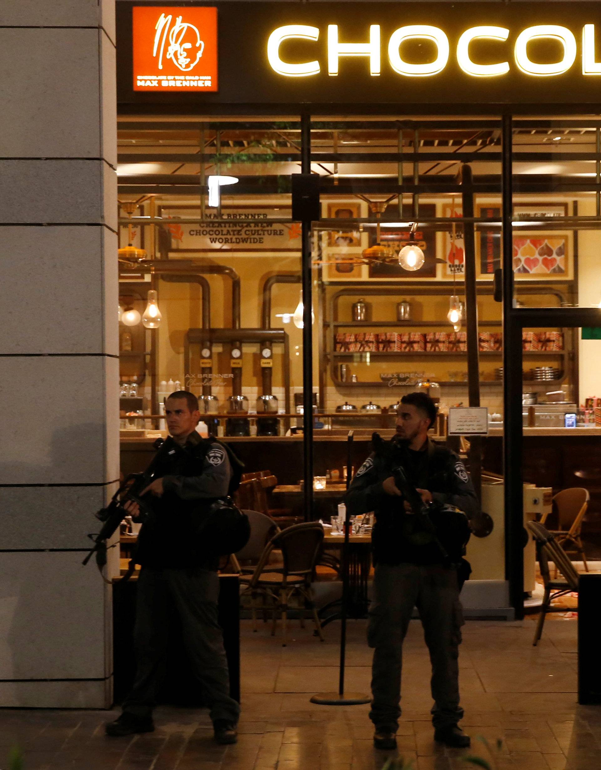 Israeli policemen secure the entrance to a restaurant following a shooting attack in the center of Tel Aviv