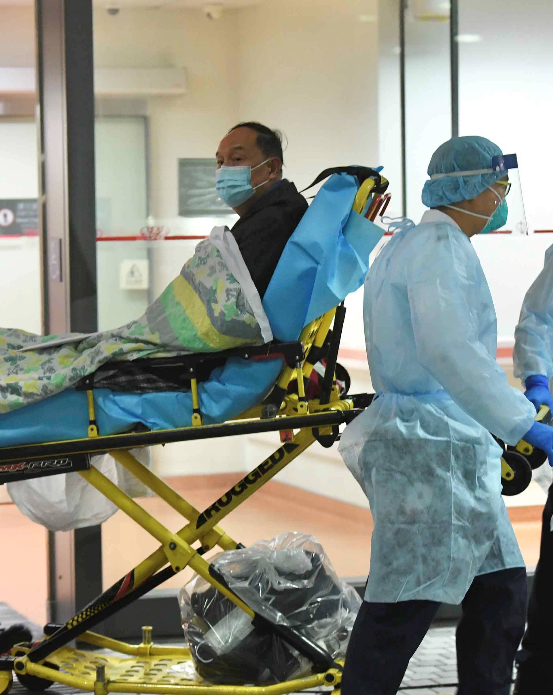 Medical staff transfer a patient of a suspected case of a new coronavirus at the Prince of Wales Hospital in Hong Kong