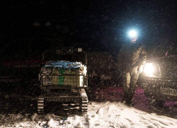 Ukrainian servicemen operate an unmanned ground vehicle fit for delivery missions on the frontline in Donetsk region
