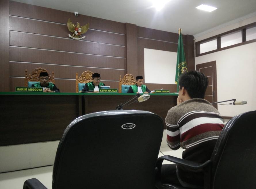 An Indonesian man sits in an Islamic court, one of the two men sentenced to 85 lashes of the cane for having sex together, in Banda Aceh, Indonesia