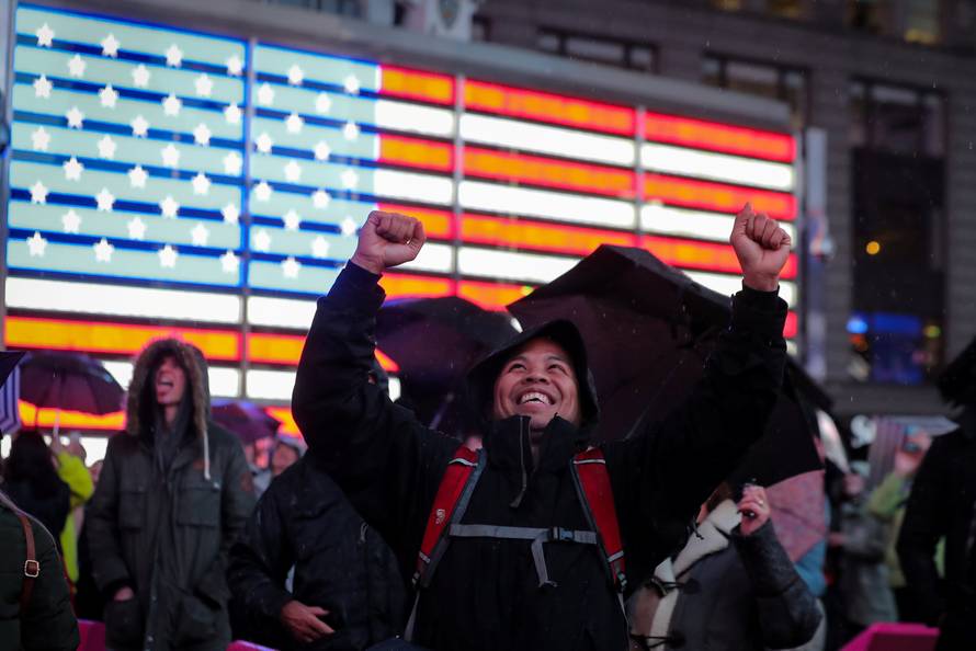 People react as they watch on a video screen as the spaceship InSight lands on Mars surface after a six-month journey, in Times Square in New York