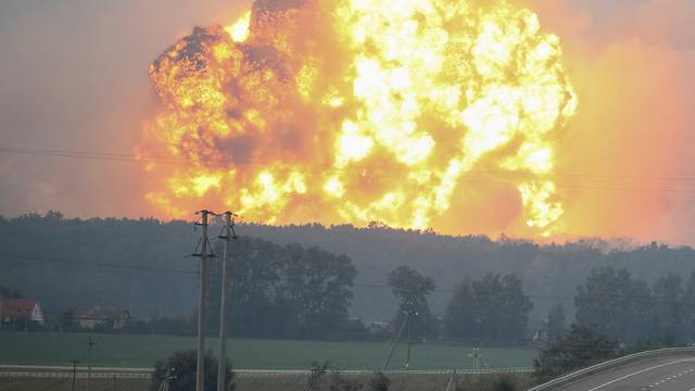 Smoke and flames rise over a warehouse storing ammunition for multiple rocket launcher systems at a military base in the town of Kalynivka