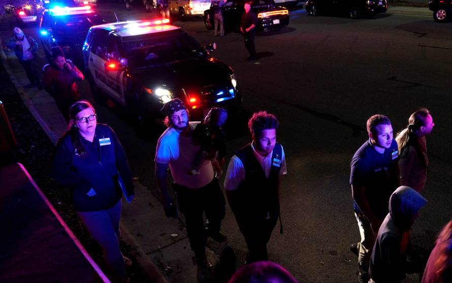 Walmart employees and shoppers leave the scene of a shooting at a Walmart in Thornton