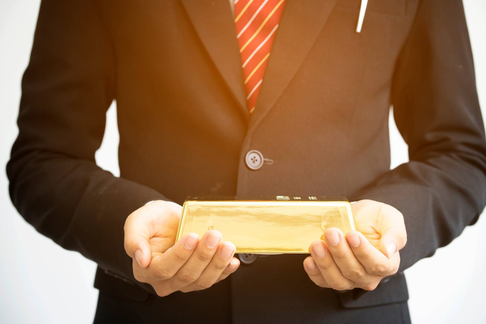 Businessman,Holding,Gold,Bar,On,White,Background