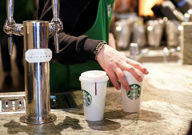 FILE PHOTO: A barista serves beverages in single use cups inside a Starbucks in London