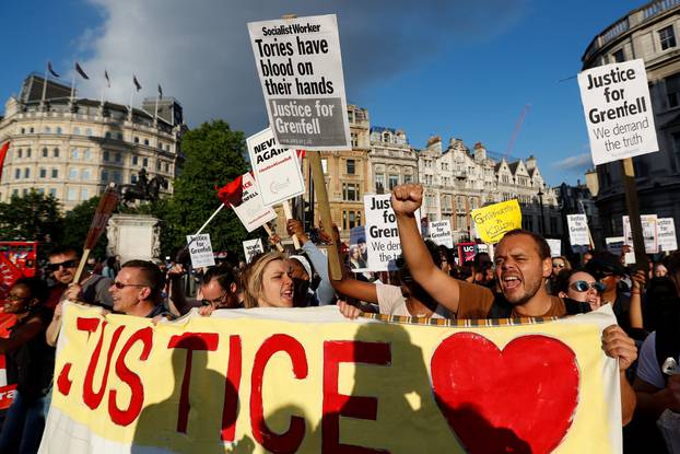 Demonstrators hold up banners during a march in Westminster, following the fire that destroyed The Grenfell Tower block, in north Kensington, West London