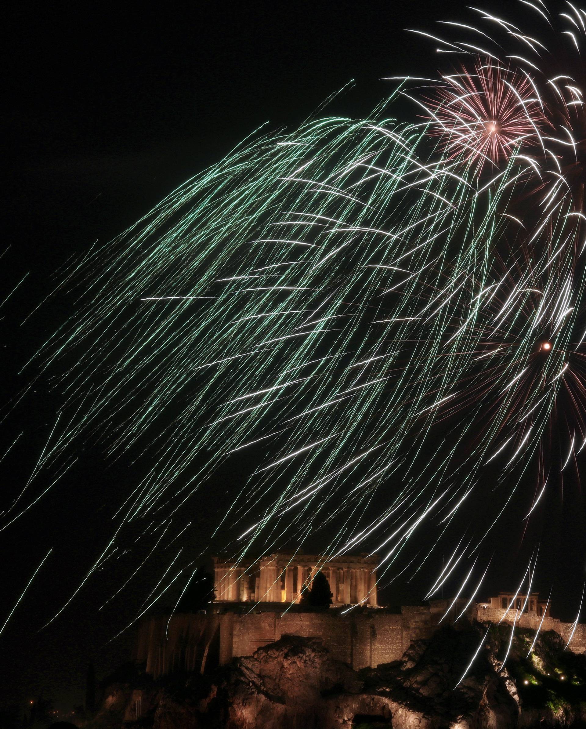 Fireworks explode over the ancient Parthenon temple atop the Acropolis hill during New Year's day celebrations in Athens