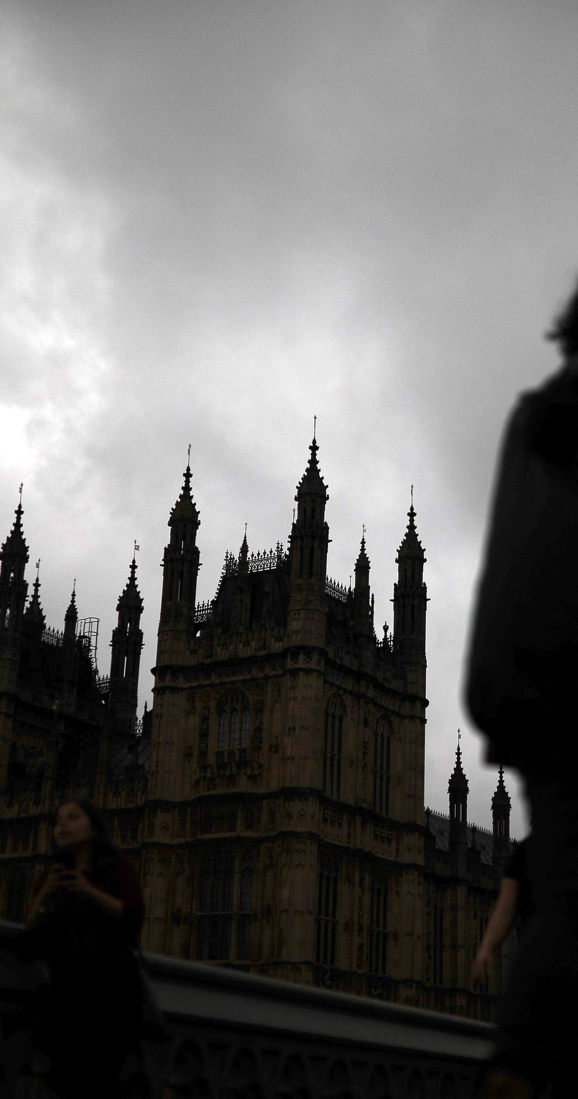 A woman walks past the Houses of Parliament and the Big Ben clock tower, on the day of the EU referendum, in central London