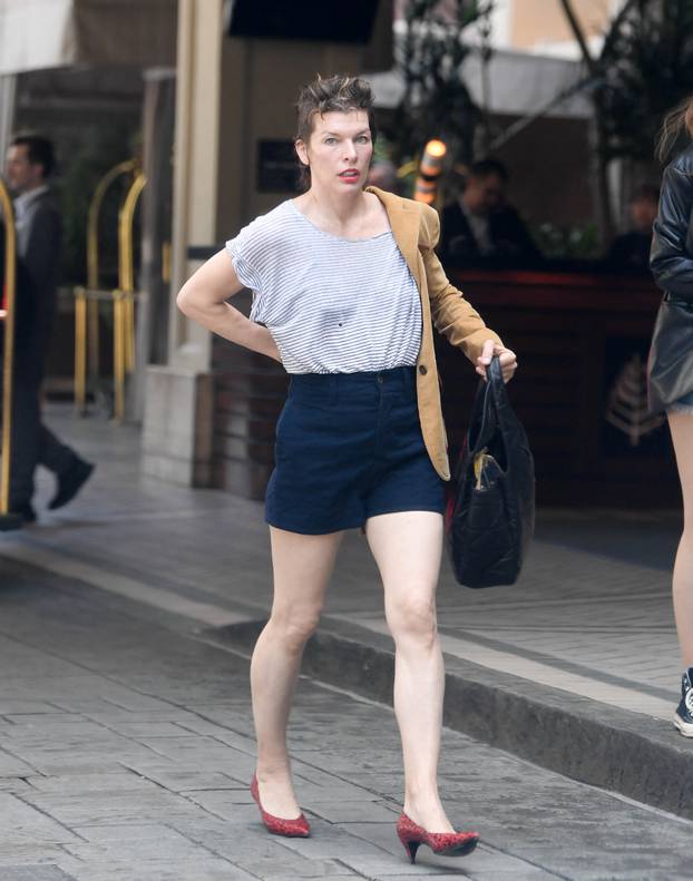 EXCLUSIVE: Mila Jovovich shows of an interesting new hairstyle as she arrives at the Four Seasons