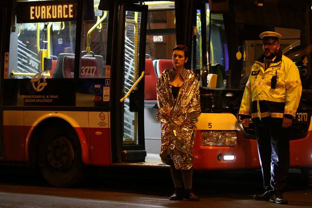 A woman is evacuated from the scene of a fire at a hotel in Prague