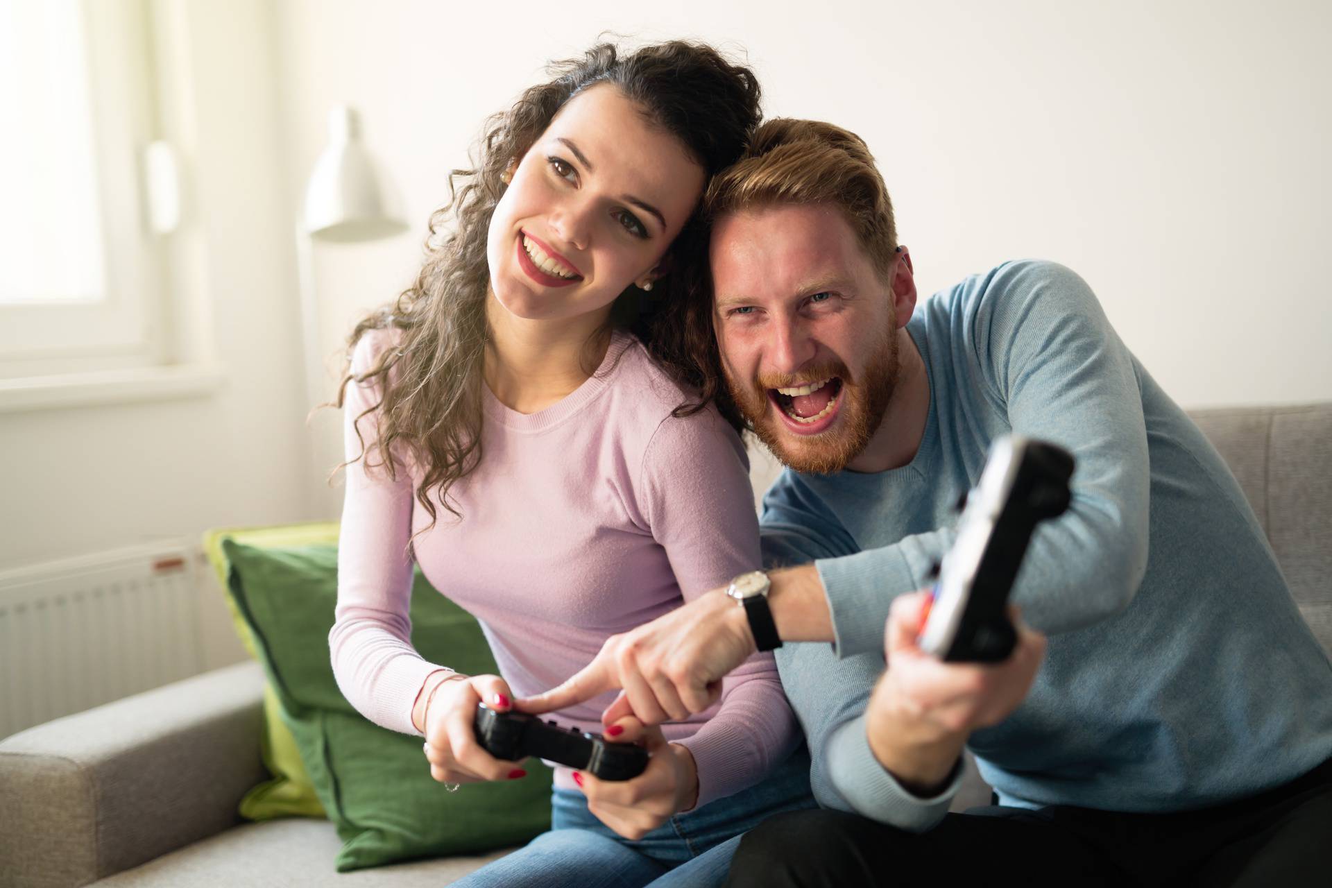 Beautiful couple playing video games on console