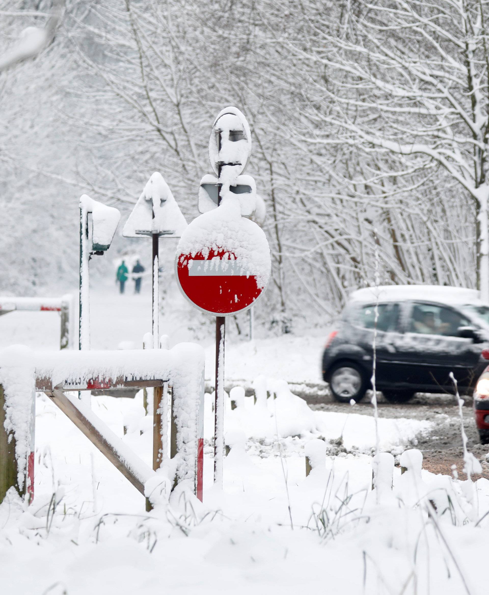 Commuters drive in the snow-covered Bois de Vincennes in Paris, France, as winter weather with snow and freezing temperatures arrive in France