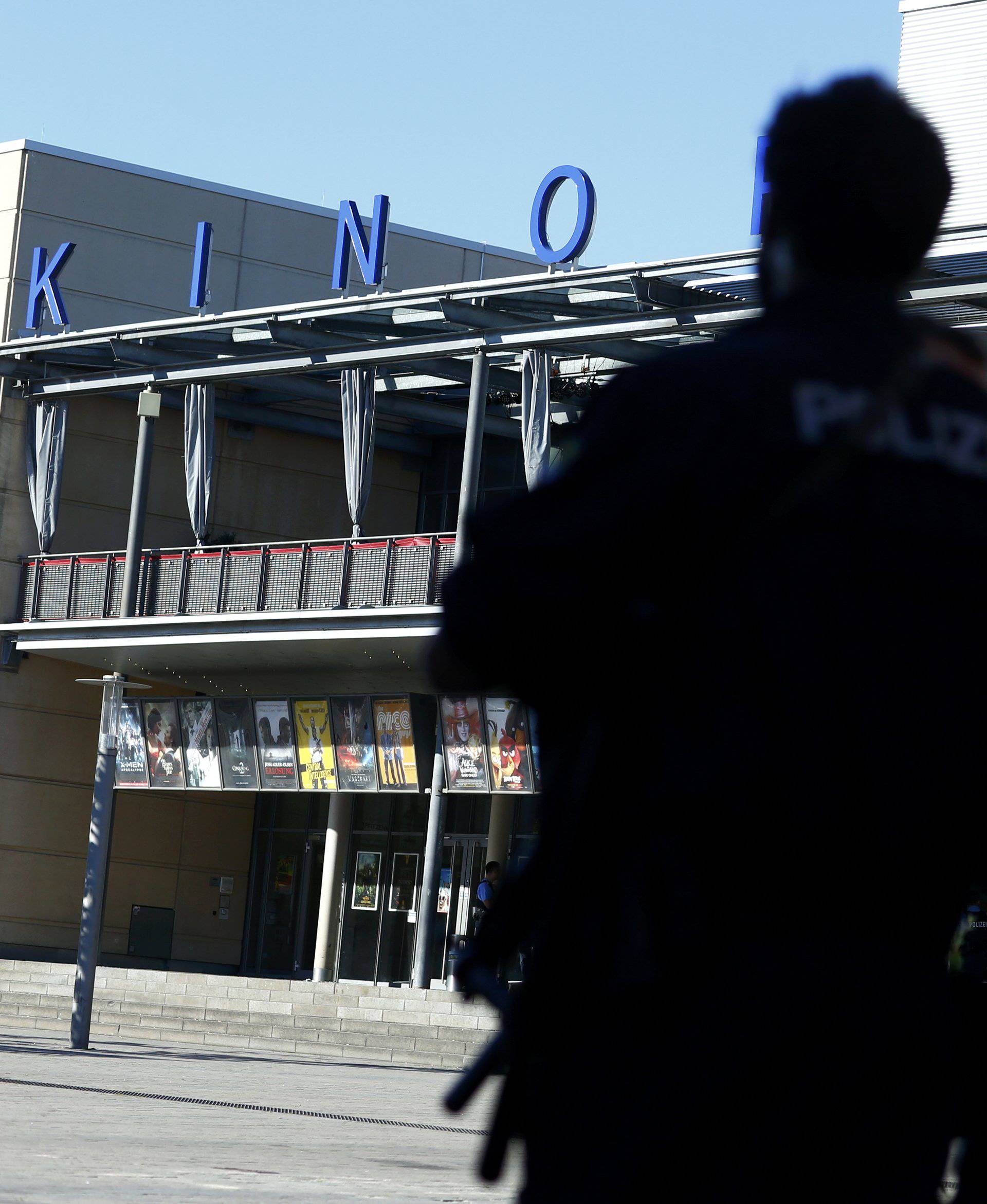 German police waits in front of a cinema complex after a masked man with a gun and ammunition belt opened fire in Viernheim