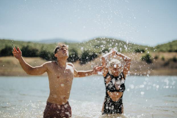 Young Adults Splashing and Enyoying A Summer Day in the Lake