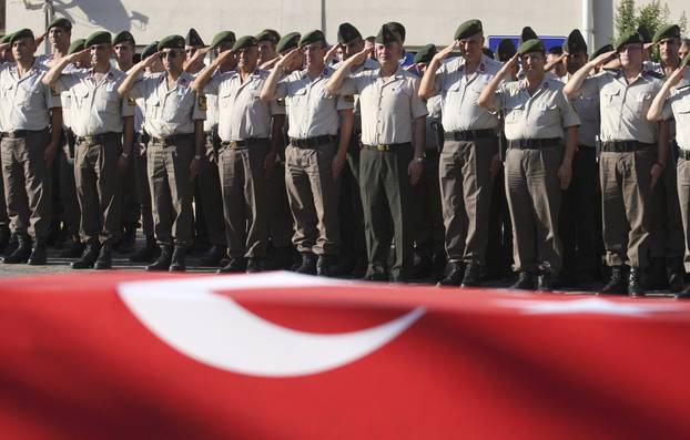 Turkish police officers salute during a funeral ceremony for police officer Nedip Cengiz Eker in Marmaris