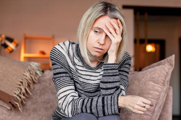 Stressed,Middle,Aged,Woman,Sit,On,Sofa,In,Living,Room,