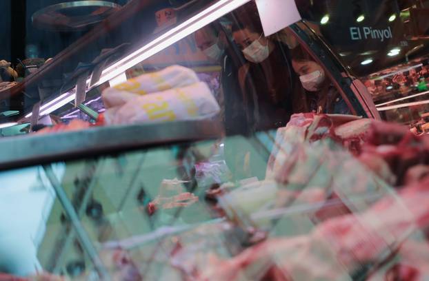 Family wear protective face masks as they buy meat at La Boqueria market, amidst concerns over  coronavirus outbreak, in Barcelona