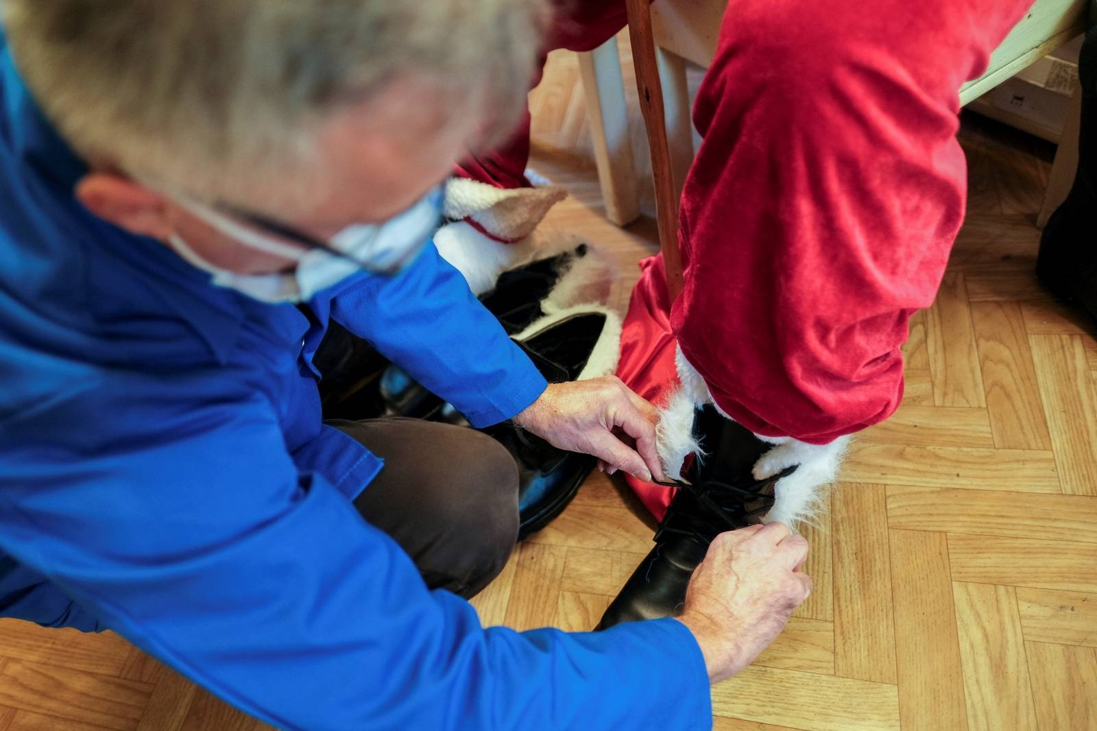 Romanian cobbler Grigore Lup ties the laces of a pair of oversized winter boots after finishing them