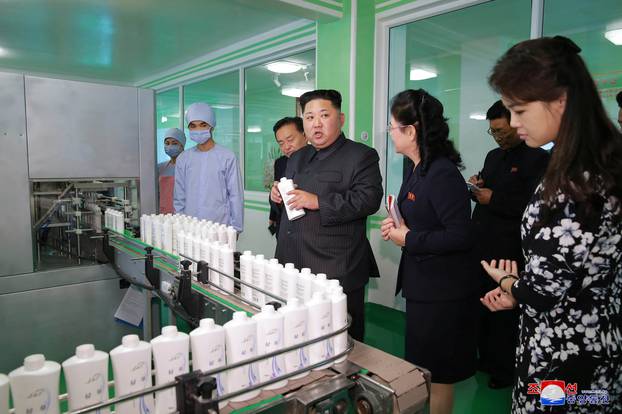 North Korean leader Kim Jong Un and wife Ri Sol Ju visit a cosmetics factory in this undated photo released by North Korea