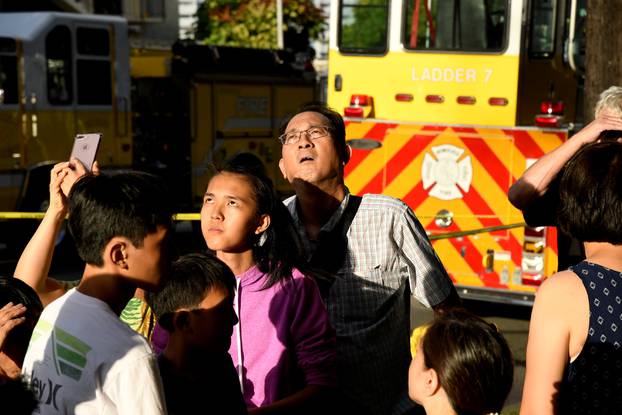 Evacuated residents look up at Marco Polo apartment building after a fire broke out in it in Honolulu, Hawaii.