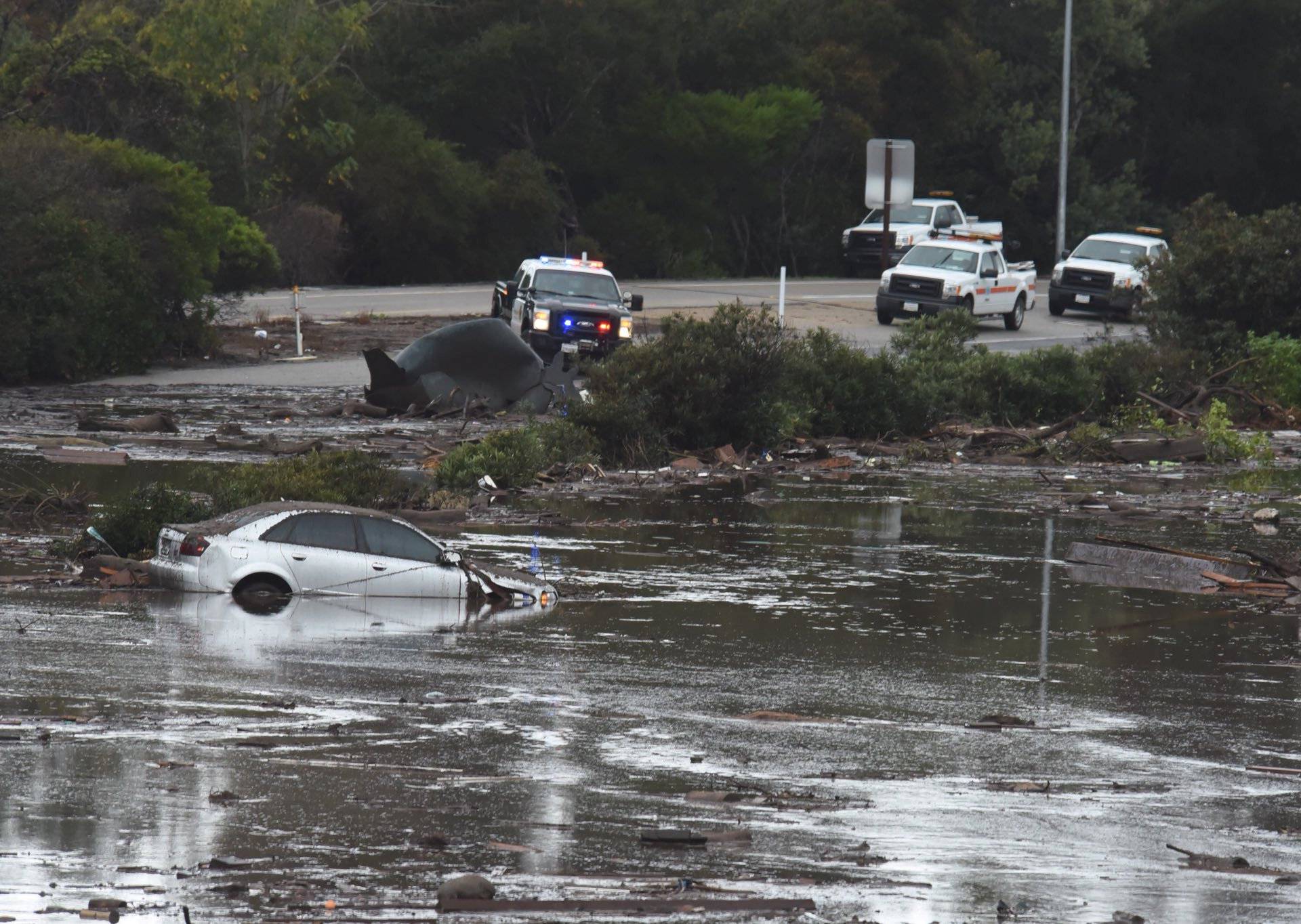 An abadoned car floats in flooded waters and debris on the freeway after a mudslide in Montecito