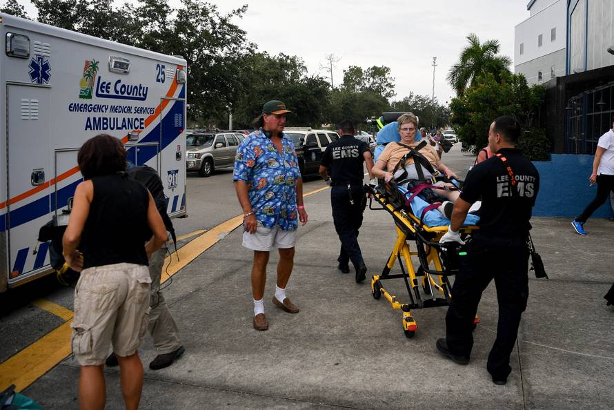 Emergency medical personnel move a woman from the Germain Arena hurricane shelter to an awaiting ambulance in Estero