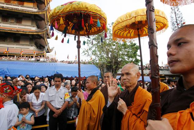 FILE PHOTO: Buddhist monk Thich Nhat Hanh waves to the believers as he walks during the requiem mass at the Vinh Nghiem pagoda in Ho Chi Minh city