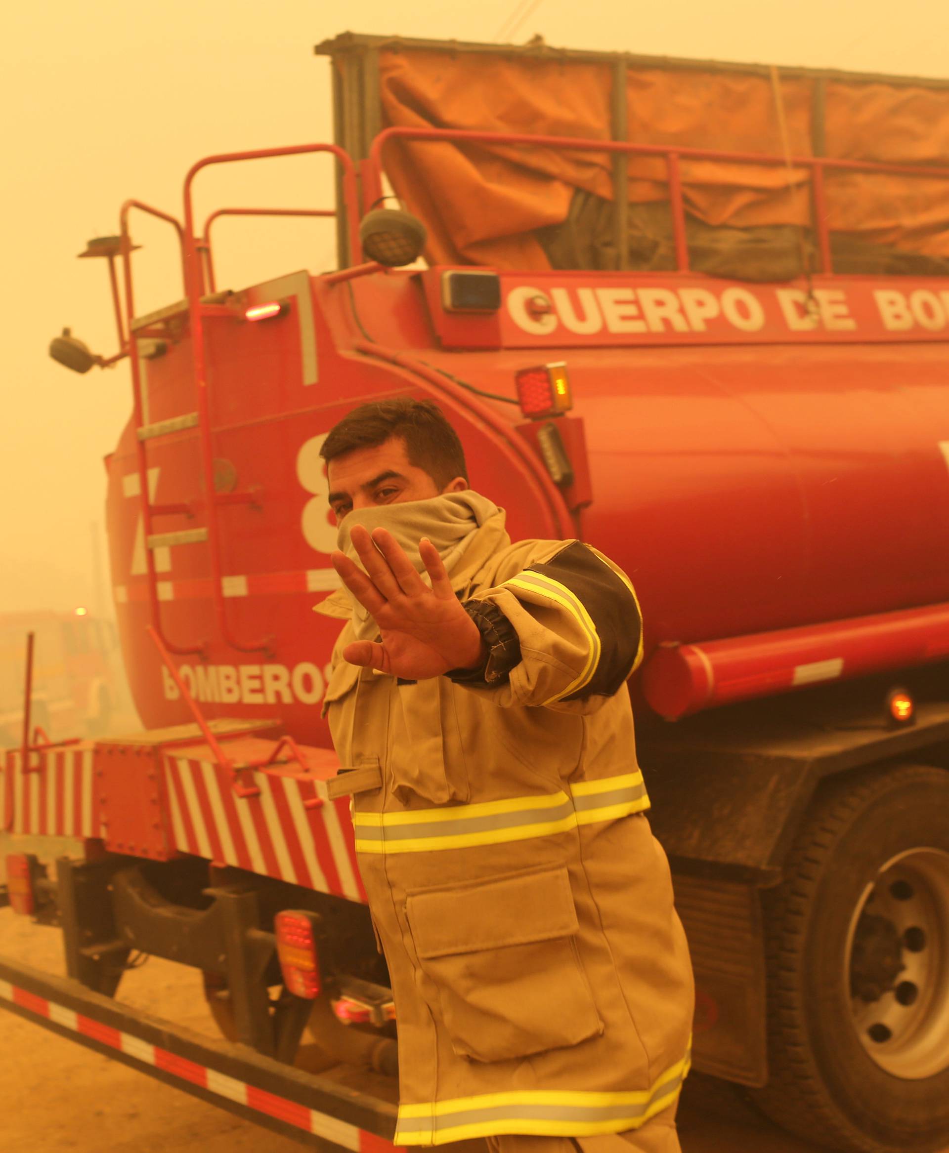 A firefighter gestures while standing near his firetruck in Santa Olga
