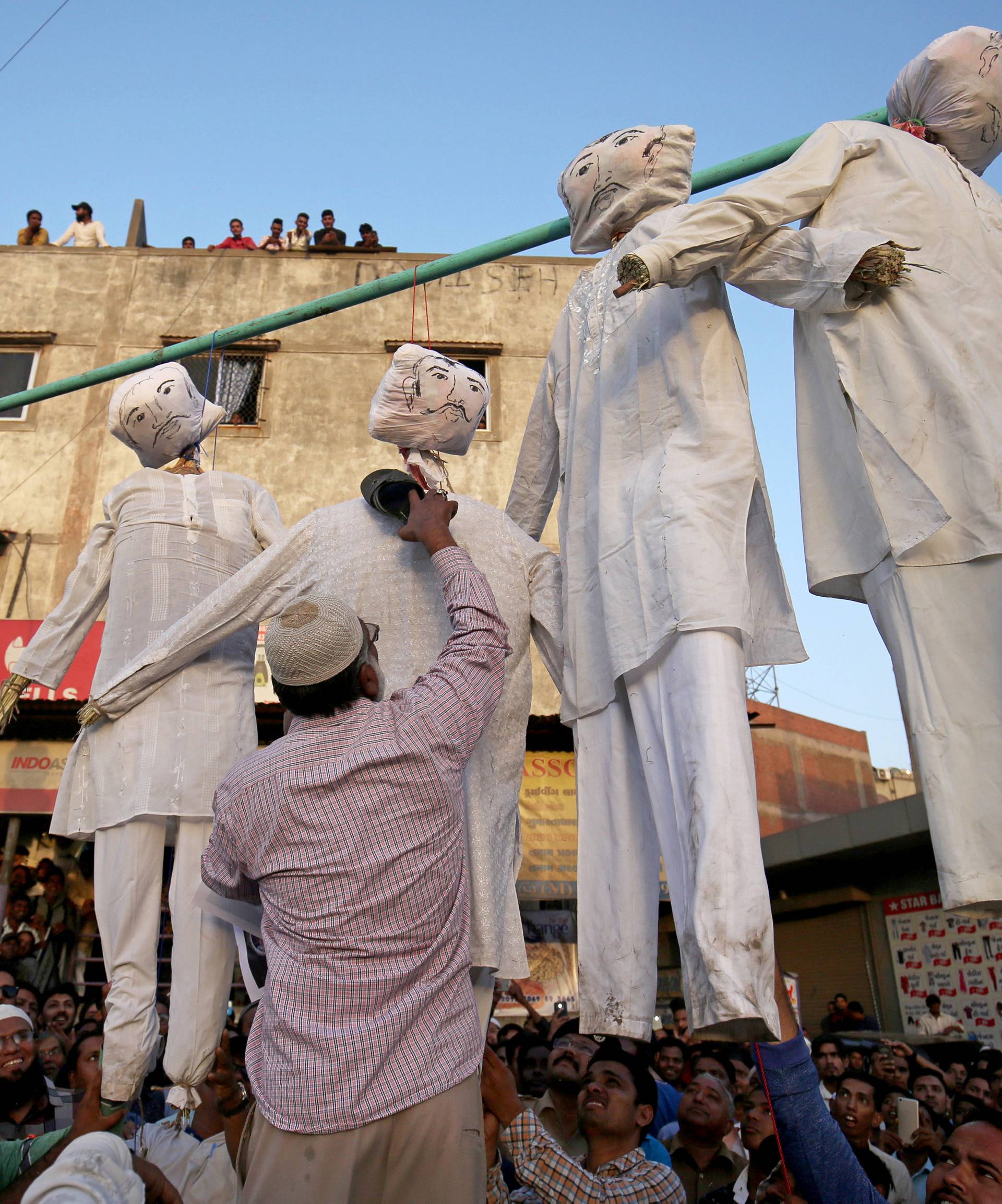 A man beats an effigy of one of the rapists at a protest against the rape of an eight-year-old girl, in Kathua, near Jammu, a teenager in Unnao, Uttar Pradesh state, and an eleven-year-old girl in Surat, in Ahmedabad