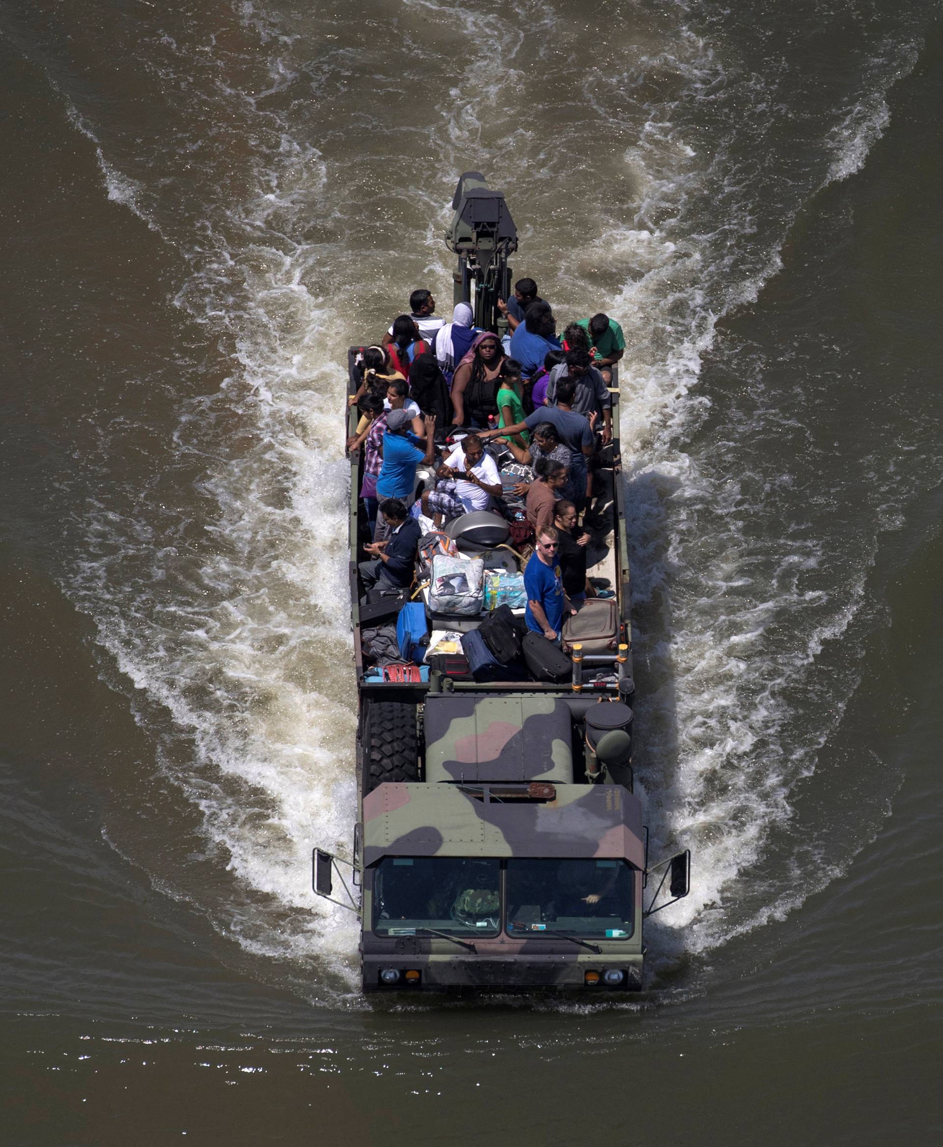 A military vehicle evacuates residents through flood waters caused by Tropical Storm Harvey in Port Arthur, Texas