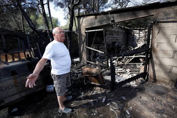 A man reacts near his destroyed home in Istres the day after fires, fanned by strong northern winds known as the mistral, ravaged more than 2,000 hectares of the dry, pine-planted hills north of Marseille