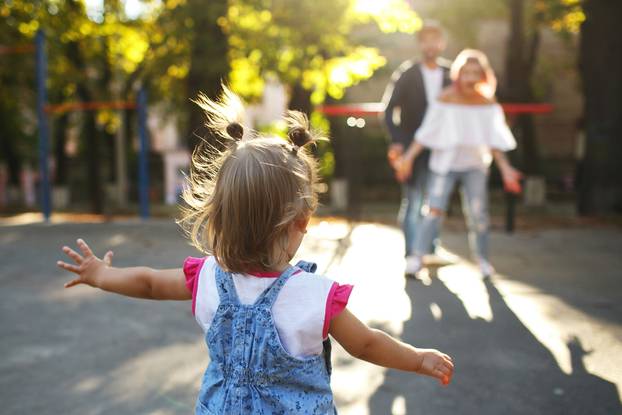 Look,From,Behind,At,Jazzy,Child,Running,To,Parents,While