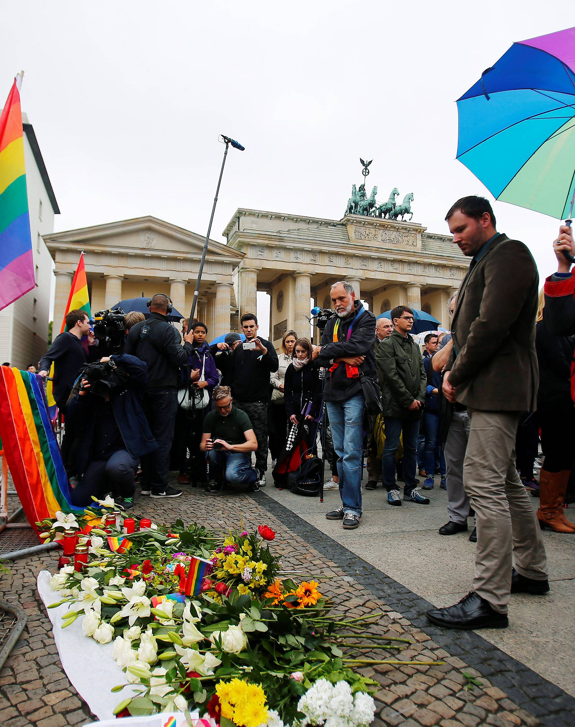 A man places a candle for the victims of the shooting at a gay nightclub in Orlando in front of the U.S. Embassy and Brandenburg gate in Berlin