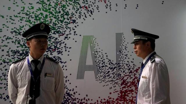 FILE PHOTO: Security officers keep watch in front of an AI (Artificial Intelligence) sign at the annual Huawei Connect event in Shanghai
