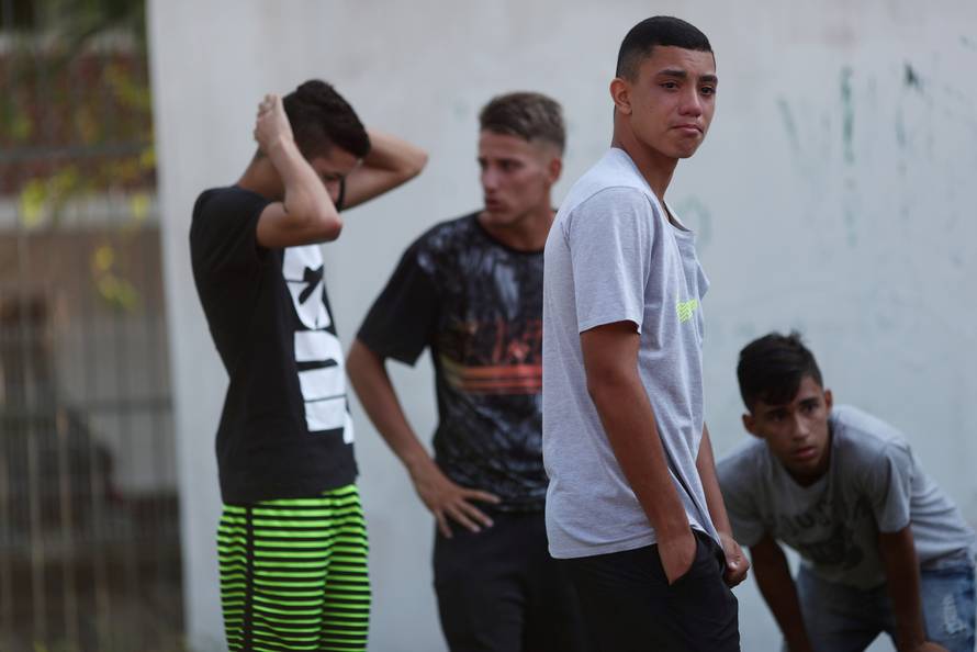People wait for information at Flamengo training center after deadly fire in Rio de Janeiro
