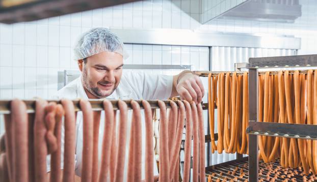 Butcher,Man,Making,Sausages,Ready,To,Be,Smoked,Putting,Them