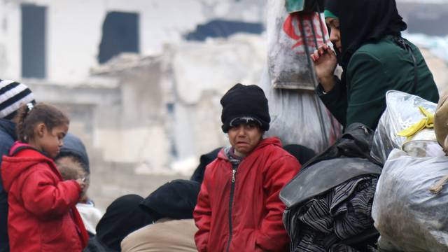 A child reacts while waiting with others to be evacuated from a rebel-held sector of eastern Aleppo