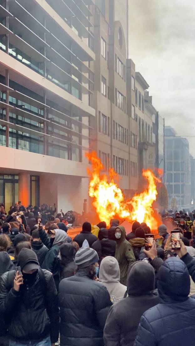 Demonstrators look at a fire during a protest, in Brussels