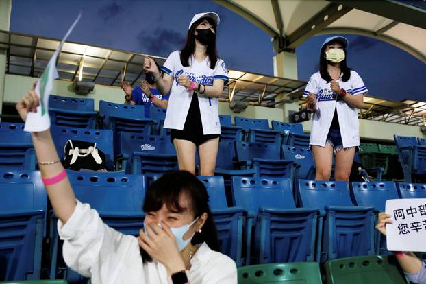 Baseball fans dance to support their team while wearing face masks at the first professional league game that allow audience since the outbreak of the coronavirus disease (COVID-19) in Taipei