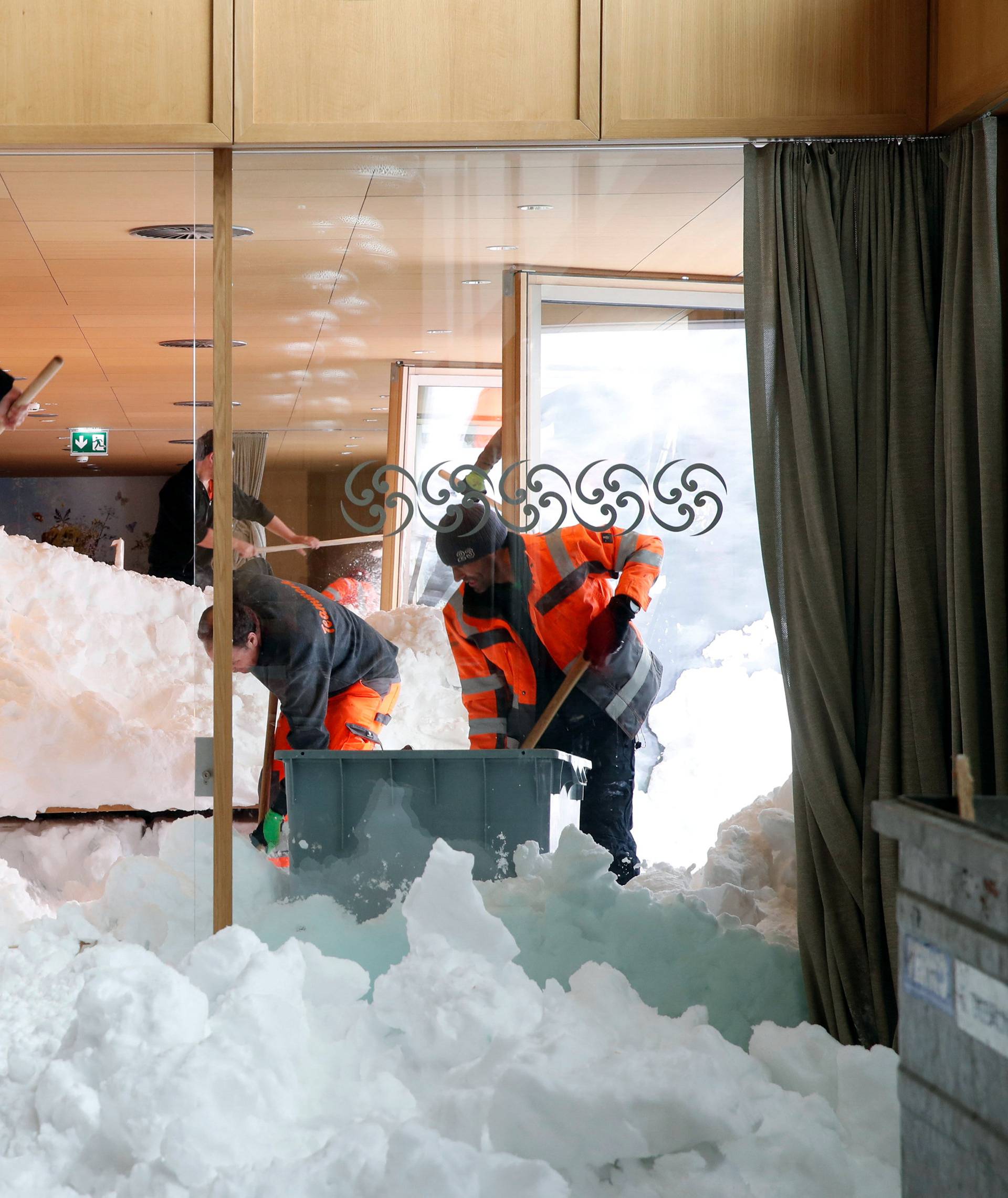 Workers shovel snow out of a restaurant after an avalanche at Santis-Schwaegalp mountain resort