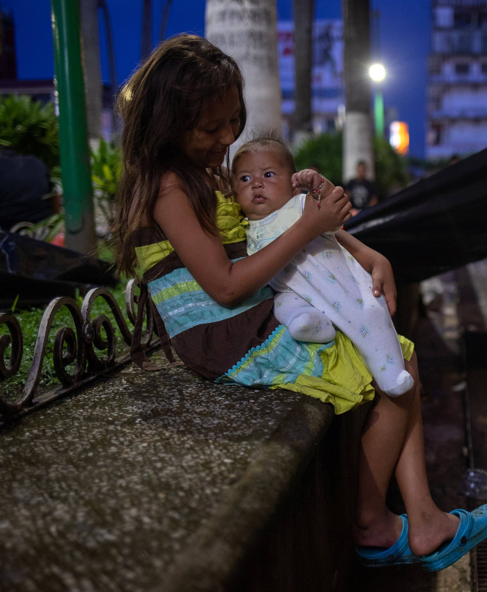 Girl holds sister amid caravan of migrants from Central America taking a rest while en route to U.S., in Tapachula, Mexico