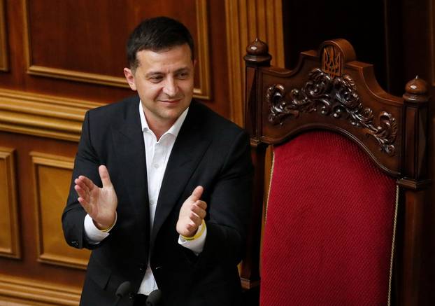 Ukrainian President Volodymyr Zelenskiy applauds during a session of parliament in Kiev